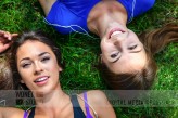wdnetstudio Top view of two beautiful and young girls rest on the grass after outdoor workout in a sunny day