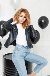 Alonesdj Beautiful young blonde girl in a black leather jacket and jeans is posing near a black metal barrel and balloons