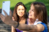 wdnetstudio Millennials lifestyle concept - two sports girls taking a selfie and smiling after outdoors training on a sunny day.