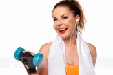 Evelyne_evi Fitness activity concept - beautiful young woman in sportswear with towel, earphones and dumbbells making workout.