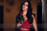 wdnetstudio Portrait of a beautiful and elegant woman holding a rose in an evening red dress