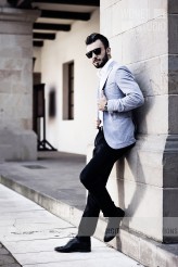 wdnetstudio Elegant fashionable man in black sunglasses posing on the background of historic architecture