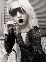 MalyDiabelek Goth style - Black lace top, black sunglasses and lips
Blonde curly/wavy hair
Tattoos 
Goth/Aesthetic 